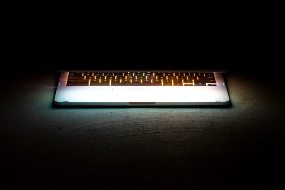 Laptop keyboard glowing in a dark room