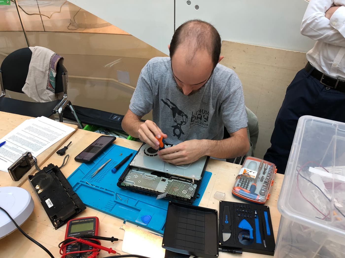 Technician repairing an opened laptop on an anti-static work mat